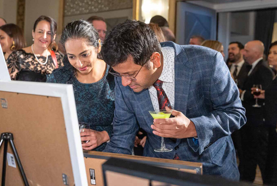 People Holding Drinks, Looking At Paintings